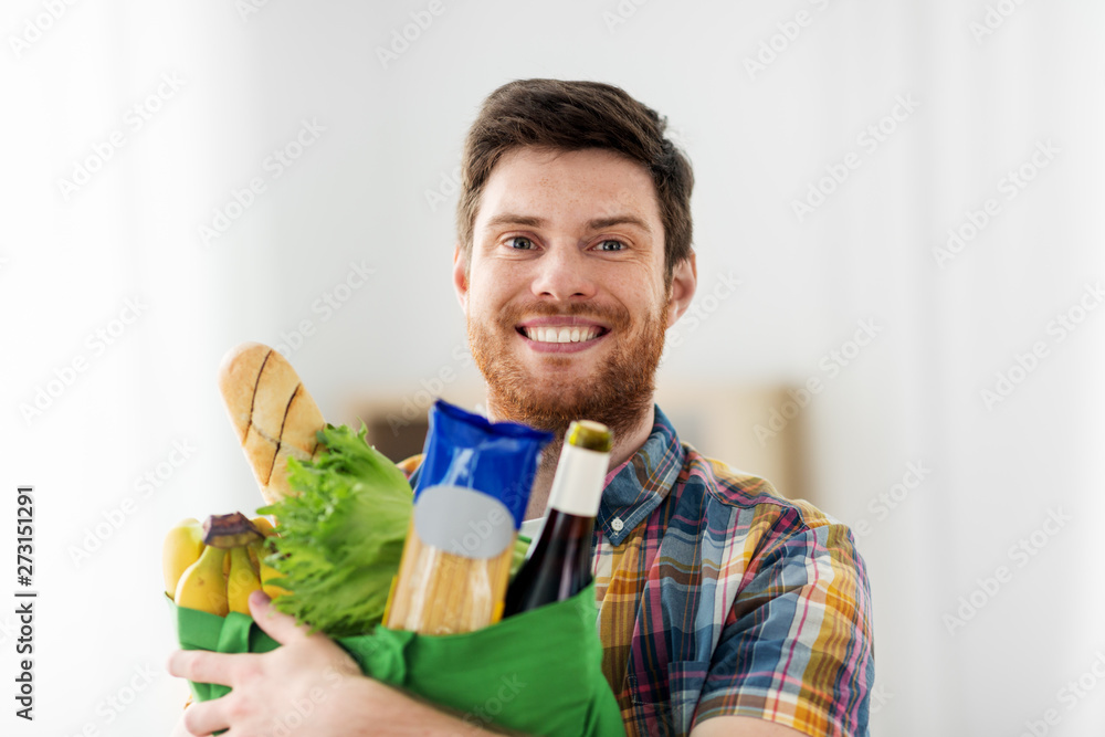shopping, consumerism and people concept - smiling young man with food in bag shopping, consumerism and people concept - smiling young man with food in bag