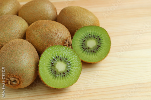 Heap of whole fruits and sliced kiwi fruits isolated on wooden background