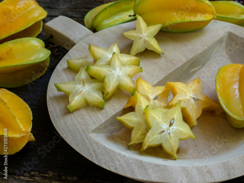 Fresh organic cut star fruit on wooden chopping board