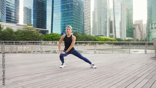 Young asian fitness woman runner stretching legs before run