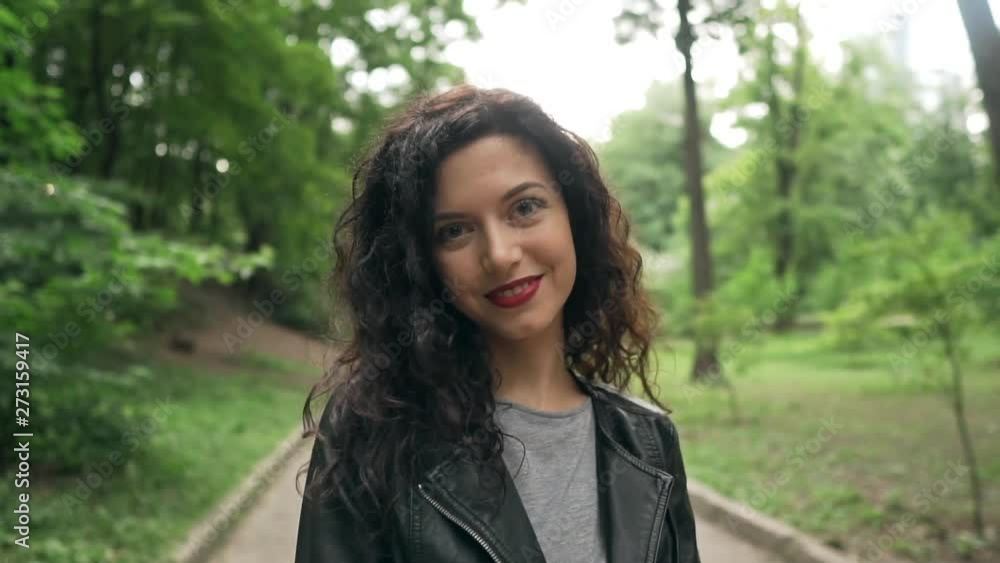 young beautiful curly brunette female smiling and walking young beautiful curly brunette female smiling and walking