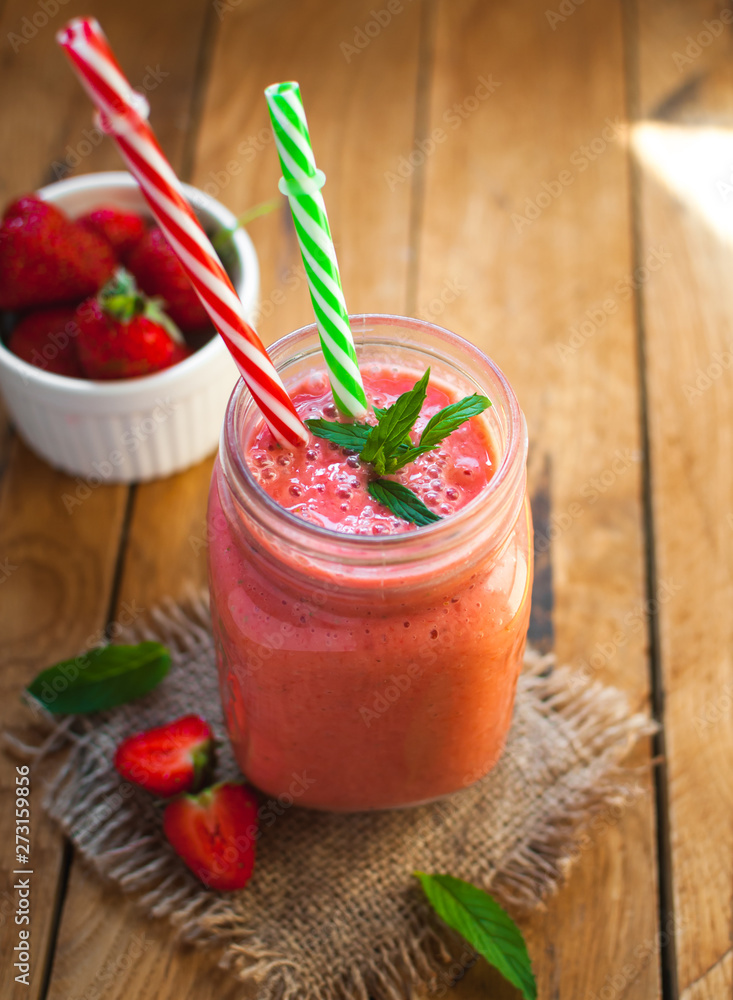 Close-up of strawberry smoothie in a glass jar with fresh mint, on wooden background Close-up of strawberry smoothie in a glass jar with fresh mint, on wooden background