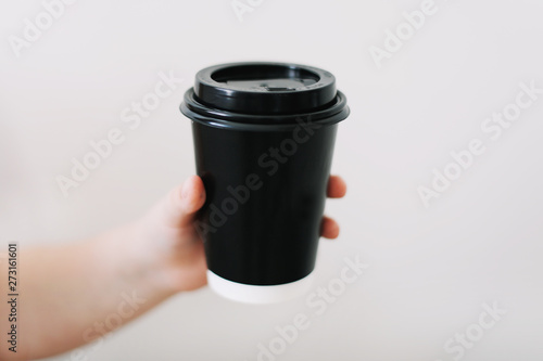 black paper cup of coffee take away. Disposable cup on a white background. Place for text.