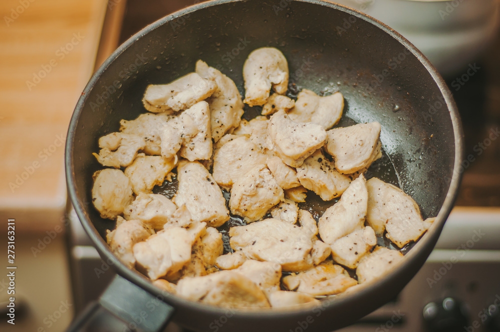 The process of cooking chicken breast diet for an athlete in a frying pan in sunflower oil. Meat for muscle recovery after exercise. The process of cooking chicken breast diet for an athlete in a frying pan in sunflower oil. Meat for muscle recovery after exercise.