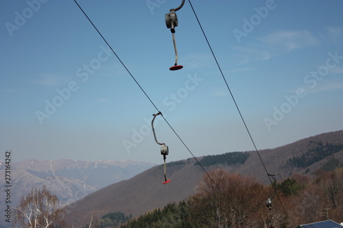 green fields. ski slopes seen in summer to careggine. paved and green path without snow, dry and arid land in Tuscany