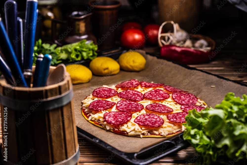 Raw pizza with cheese and salami Raw pizza with cheese and salami