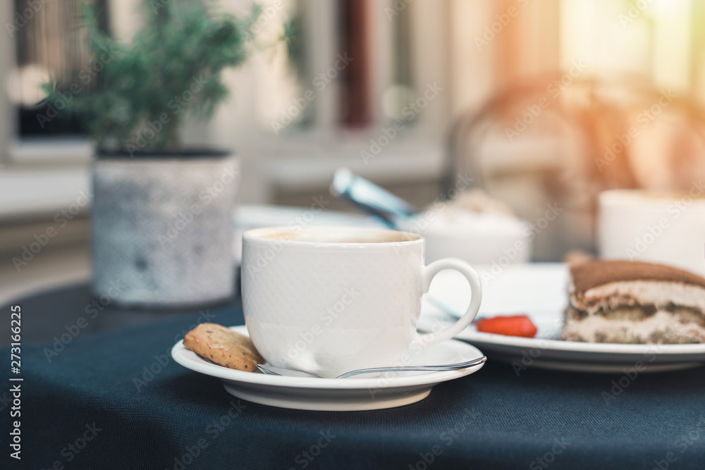 Two cups of coffee and tiramisu on black table background with beautiful latte art heart shaped. Two cups of coffee and tiramisu on black table background with beautiful latte art heart shaped.