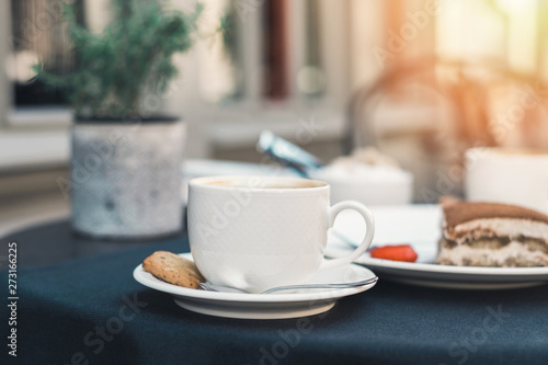 Fototapeta Naklejka Na Ścianę i Meble -  Two cups of coffee and tiramisu on black table background with beautiful latte art heart shaped.