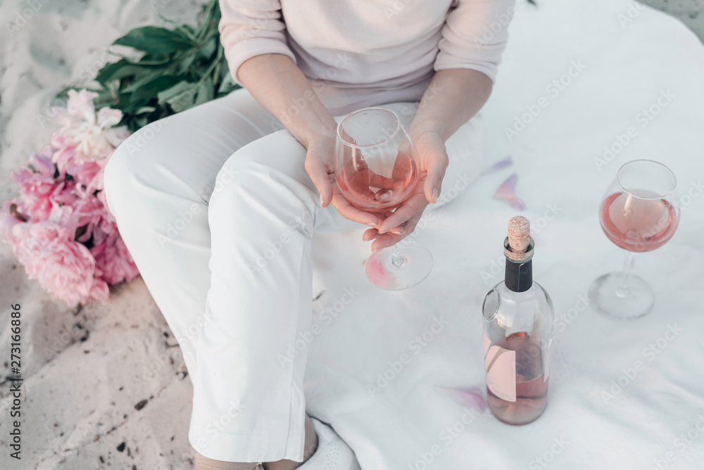 Glass of rose wine in woman's hand on picnic. Cropped. Glass of rose wine in woman's hand on picnic. Cropped.
