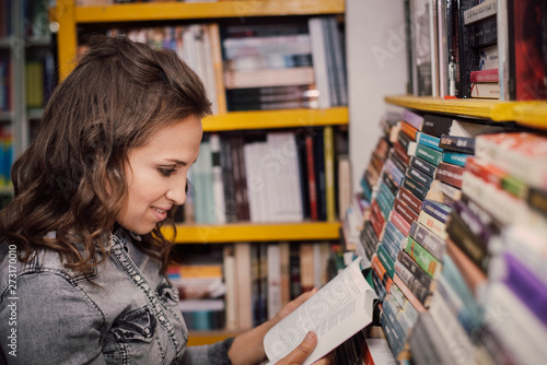 Female student picking a book in the bookstore