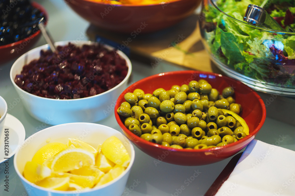 Fresh vegetables, herbs, olives, sauce and salad dressing at the counter. Fresh vegetables, herbs, olives, sauce and salad dressing at the counter.
