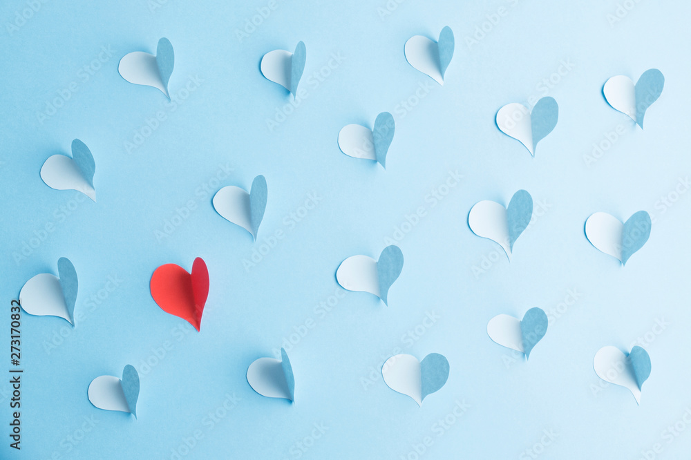 Red paper heart surrounded with blue hearts. Love concept with paper hearts on blue.. Red paper heart surrounded with blue hearts. Love concept with paper hearts on blue..