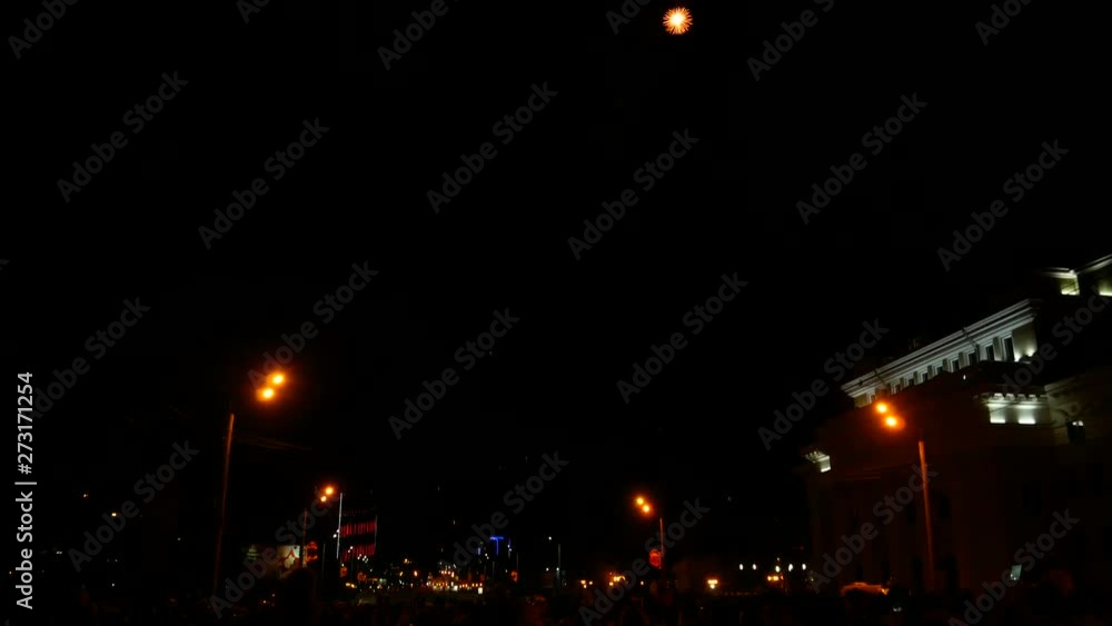 Fireworks fly in the sky. City's public celebration. Solemn firing of blank charges from artillery shells, the tradition of military parades. Multicolored firework explosions. Fireworks fly in the sky. City's public celebration. Solemn firing of blank charges from artillery shells, the tradition of military parades. Multicolored firework explosions.