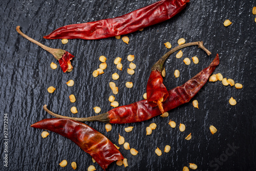 Dried Mexican Red Chile De Arbol Pepper on black natural stone background. Capsicum annuum.