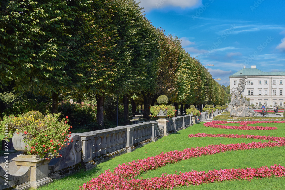Alley in park with flowers and sheared bushes in Salzburg Austria at autumn