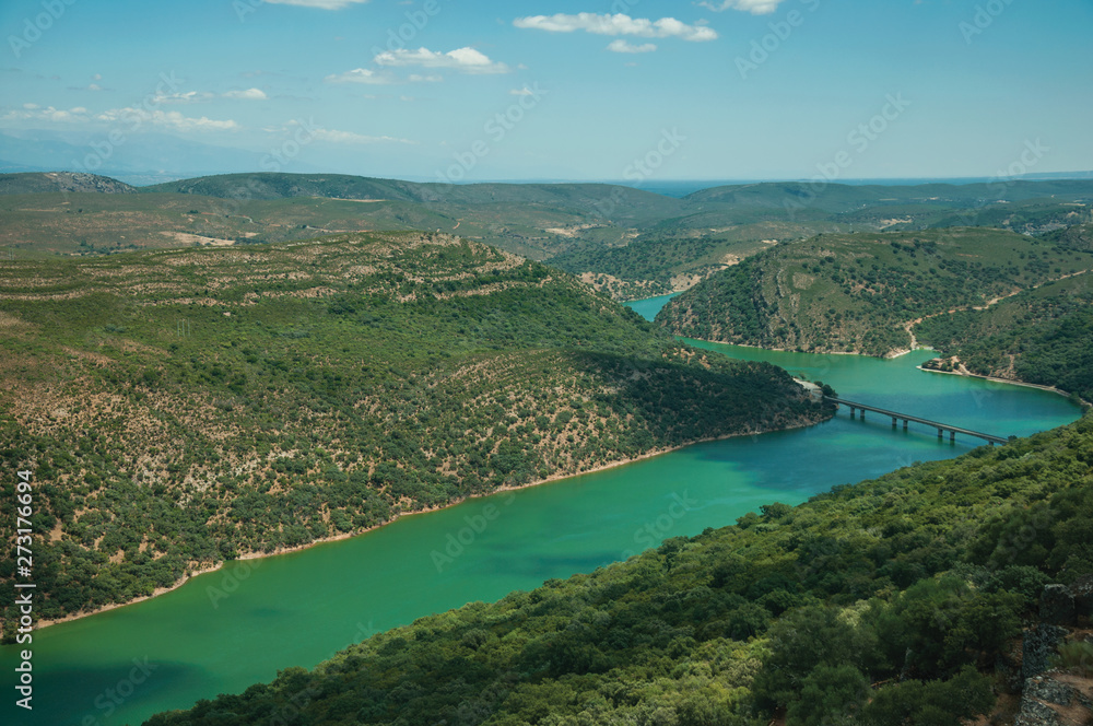 Tagus River and bridge in a valley with hills covered by trees