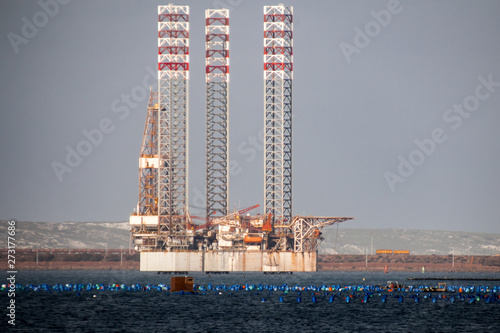 Oil rig moored in harbor with legs lifted