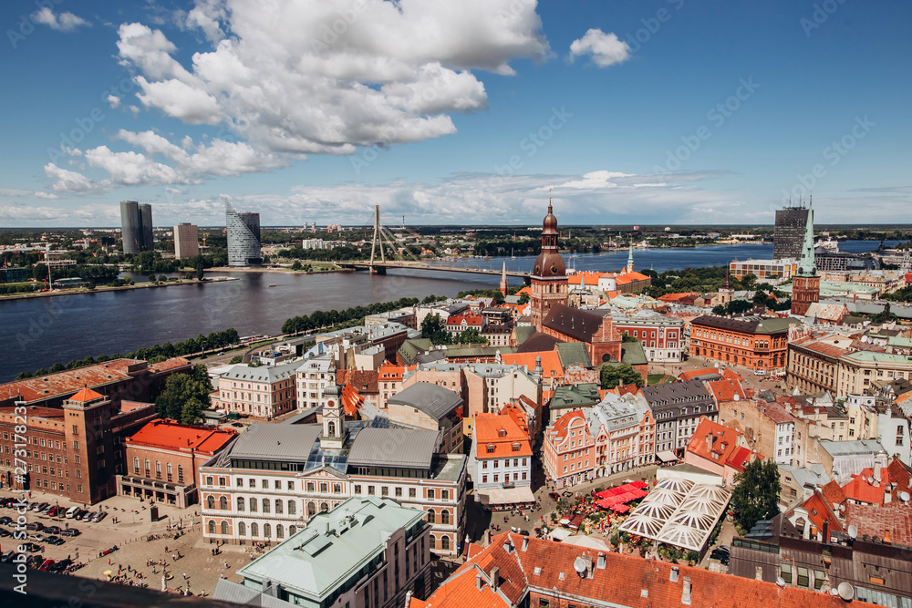 Naklejka premium Red roofs of old Riga. Riga cityscape on a sunny summer day. City aerial view of the old town with the Dome Cathedral and the Daugava River in the city of Riga, Latvia