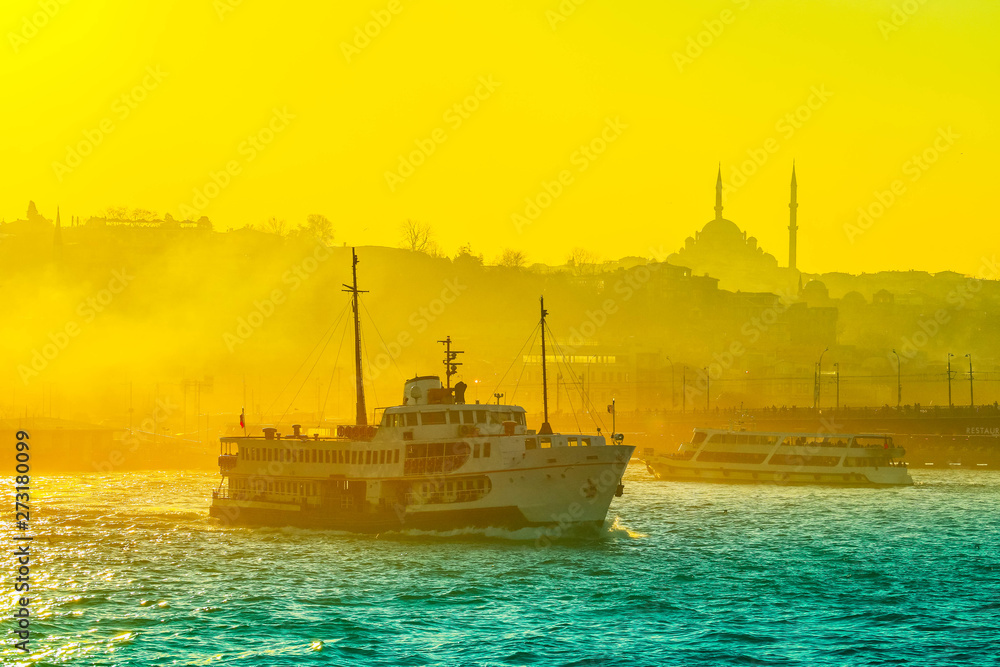 Istanbul evening sunset light, public cruise yacht in Bosporus water.