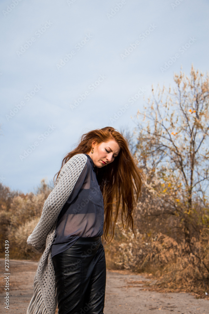 Young redhead woman with scarf in autumn park