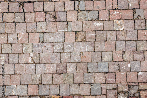 Pavement texture. An old stoneblock pavement cobbled with square granite blocks. Urban Pavement Surface