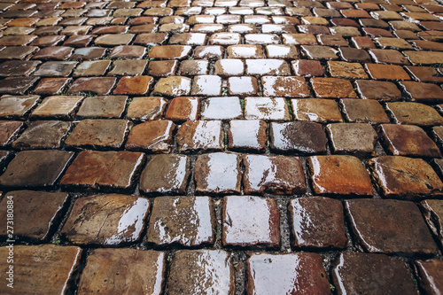cobblestone road  texture photographed from above. Stone pavement texture gray and brown color  wet pavement. top view close up