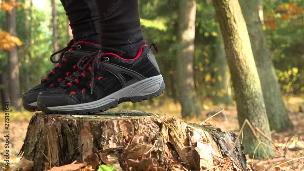 A woman steps onto a stump, looks around, and walks on - closeup on the stump A woman steps onto a stump, looks around, and walks on - closeup on the stump