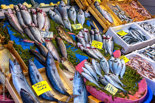 ISTANBUL, TURKEY - APRIL 04, 2019: Fish presented for sale at the fish market near Galata Bridge called Karakoy Balik Pasari. A fish store with variety of fishes and sellers in public market. photo