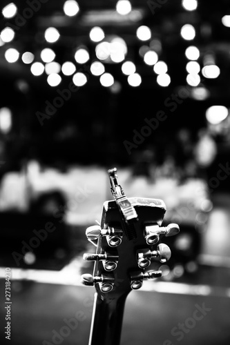 Canvas Print Concert flair: Close up of guitar neck, empty seats and lights in the blurry bac