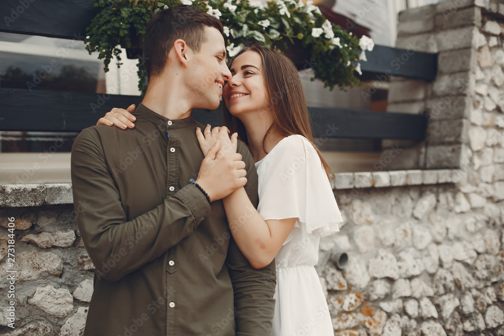 Cute couple in a city. Lady in a white dress. Boy in a green shirt