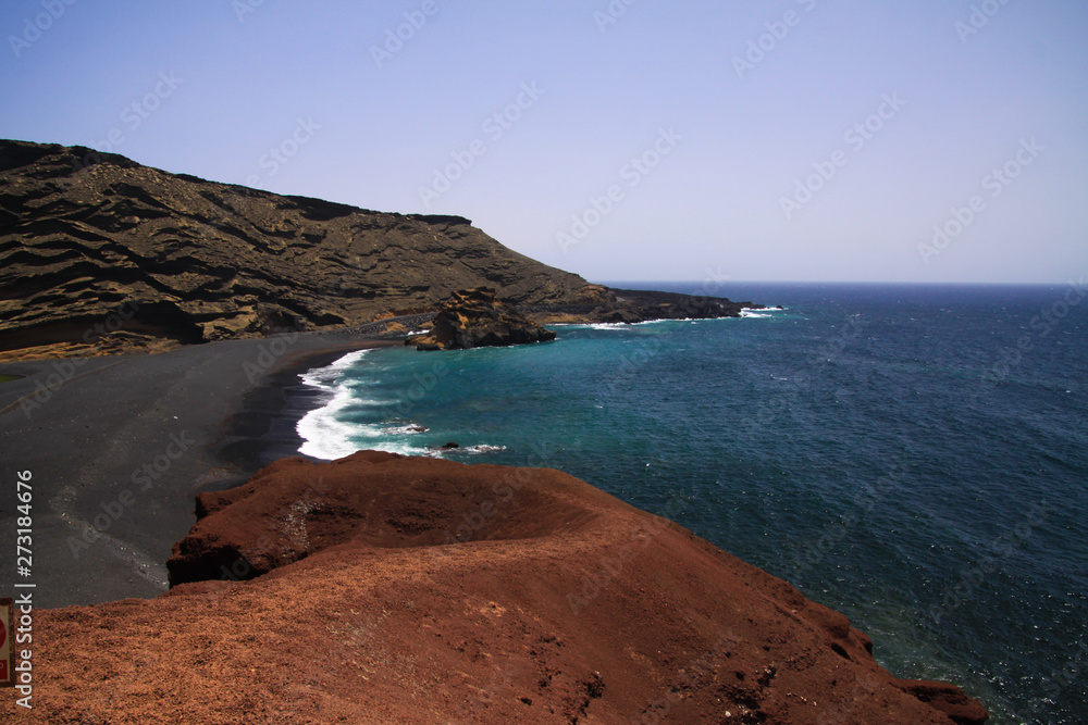 View on secluded lagoon surrounded by impressive rugged weathered cliffs in different colors - El Golfo, Lanzarote View on secluded lagoon surrounded by impressive rugged weathered cliffs in different colors - El Golfo, Lanzarote