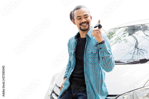 Happy young man twisting a new car key on studio