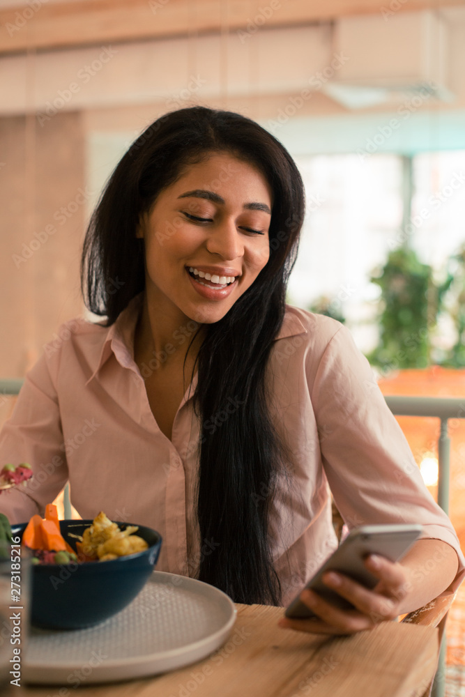 Long haired lady using smartphone while eating her lunch Long haired lady using smartphone while eating her lunch