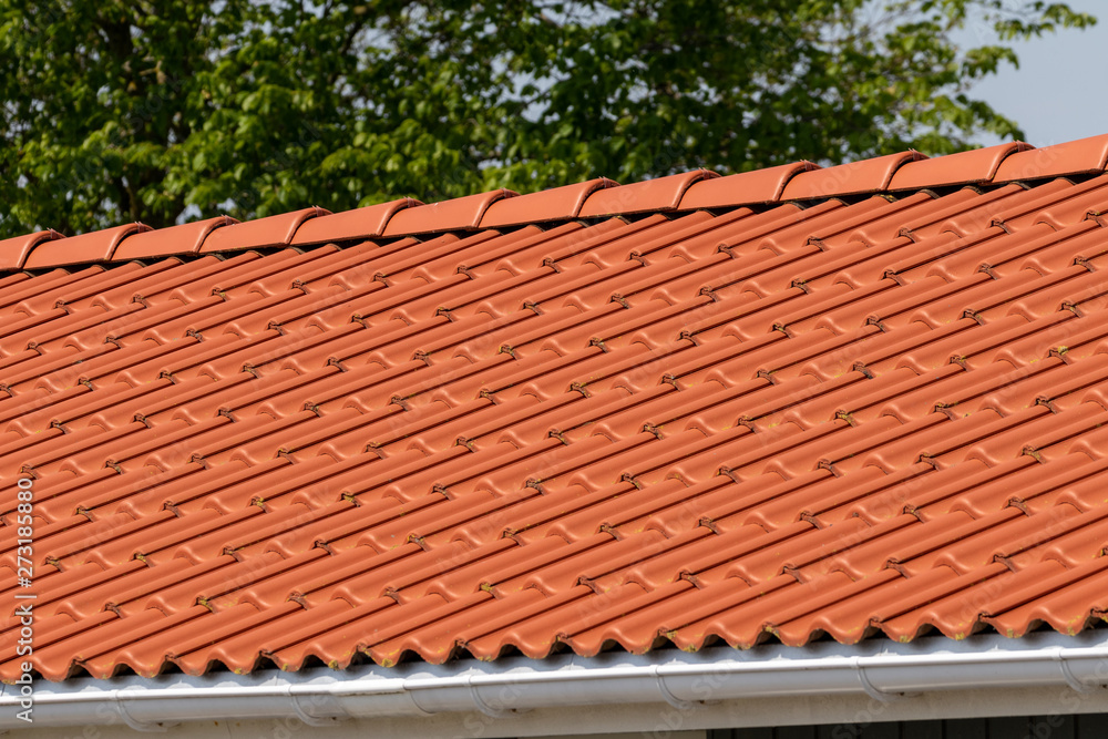 Orange pantiles on the roof of a small house 