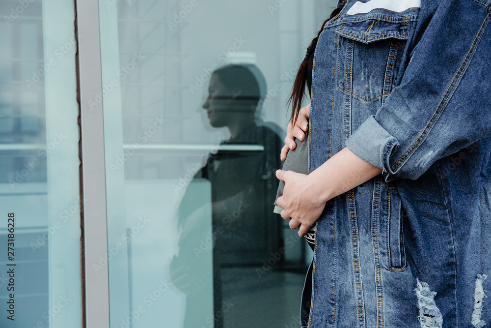A pregnant woman is holding her belly. The concept of pregnancy, expect a child. The joy of being a future mother, problems during pregnancy. A pregnant woman is holding her belly. The concept of pregnancy, expect a child. The joy of being a future mother, problems during pregnancy.