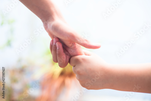 Female hand trying to conquer her fears and obstacles by holding male’s hand. Concept of Father’s day and women’s day. Horizontal shot with bokeh background. Losing the grip of the elder.