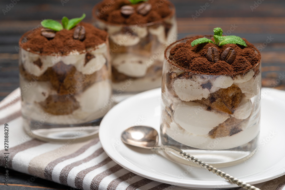 Classic tiramisu dessert in a glass on wooden background Classic tiramisu dessert in a glass on wooden background