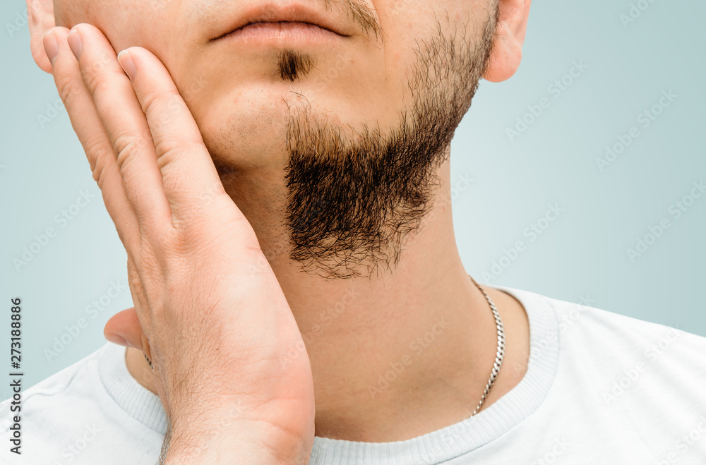 Before and after facial hair of a man on a blue, pastel background. The concept of personal hygiene in a man. A man with a beard and no beard. Shaving and taking care of facial hair. Before and after facial hair of a man on a blue, pastel background. The concept of personal hygiene in a man. A man with a beard and no beard. Shaving and taking care of facial hair.