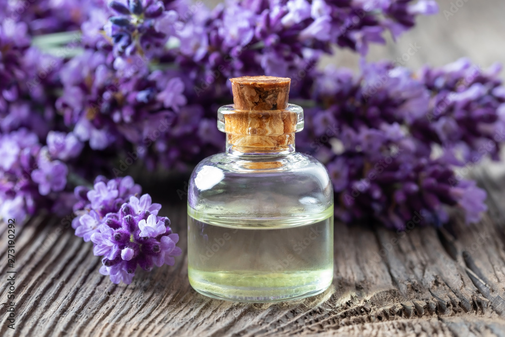 A bottle of lavender essential oil with fresh lavender A bottle of lavender essential oil with fresh lavender