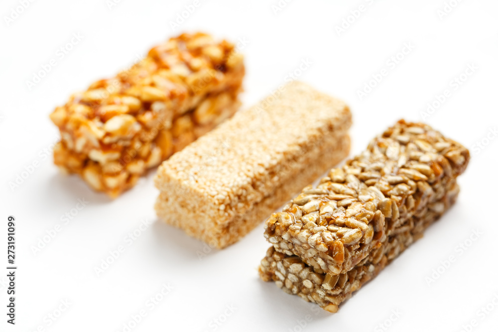 Grain granola bar with peanuts, sesame and seeds in a row on a white background. Top view Three assorted bars, isolate Grain granola bar with peanuts, sesame and seeds in a row on a white background. Top view Three assorted bars, isolate