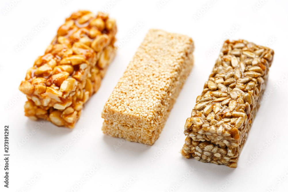 Grain granola bar with peanuts, sesame and seeds in a row on a white background. Top view Three assorted bars, isolate Grain granola bar with peanuts, sesame and seeds in a row on a white background. Top view Three assorted bars, isolate