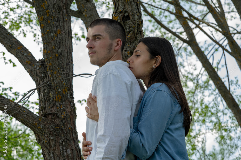 Couple of young beautiful man and woman hugging outdoors at sunny summer day. Couple of young beautiful man and woman hugging outdoors at sunny summer day.