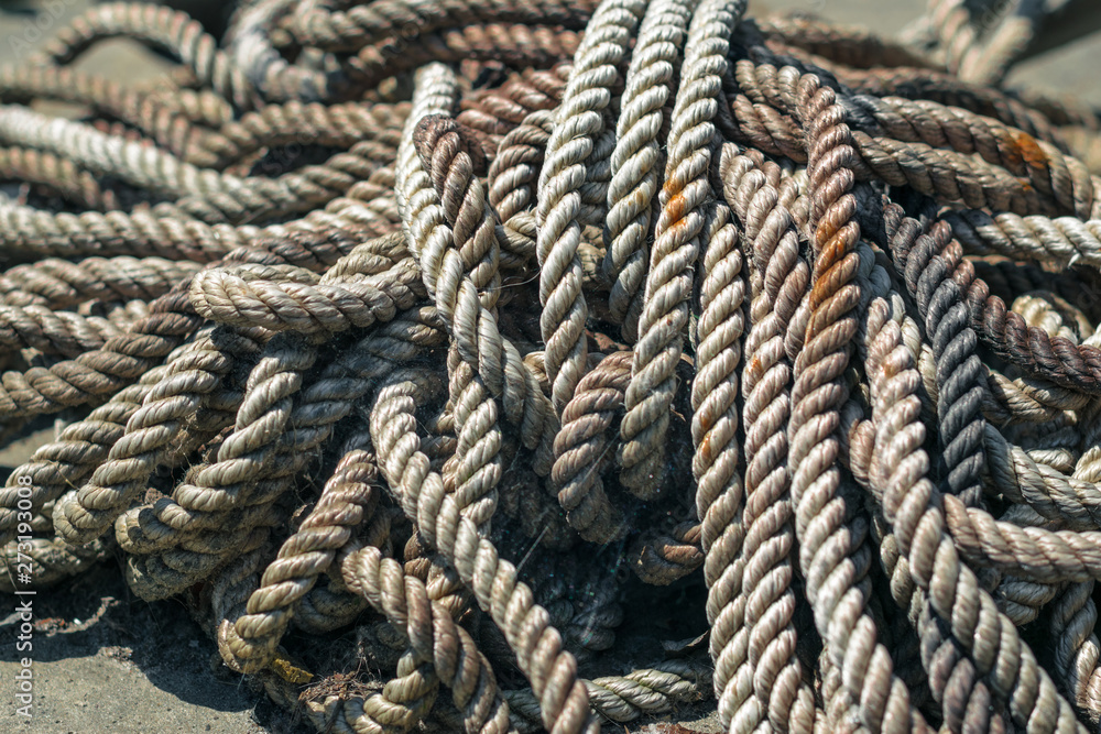 Thick rope in the web and rust. Anchor halyard. Old dirty rope