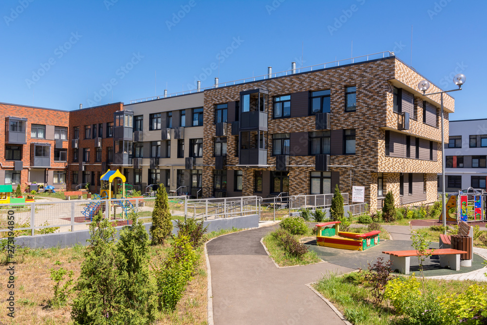 New three-storey residential building. Playground in the yard. New residential area
