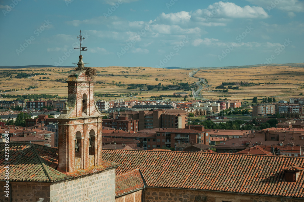 Church bell tower made of bricks amid roofs at Avila Church bell tower made of bricks amid roofs at Avila