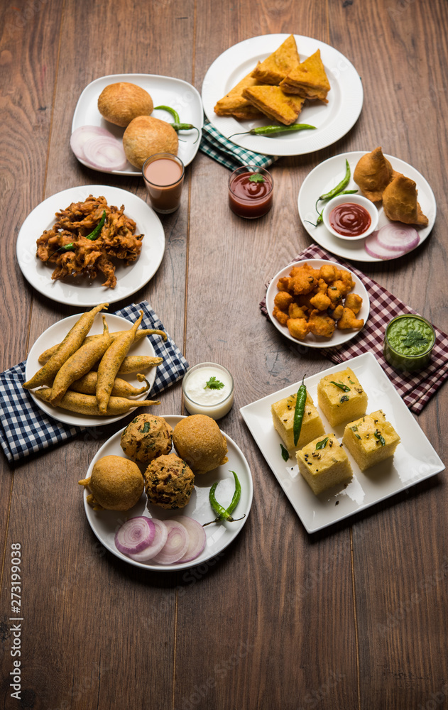 Indian Tea time snacks in group includes Veg Samosa, Kachori/kachaudi, aloo bonda, khaman dhokla, bread, onion,chilli and moong pakora/pakoda/bhaji/bhajji/Bhajiya/bajji with sauces, selective focus Indian Tea time snacks in group includes Veg Samosa, Kachori/kachaudi, aloo bonda, khaman dhokla, bread, onion,chilli and moong pakora/pakoda/bhaji/bhajji/Bhajiya/bajji with sauces, selective focus