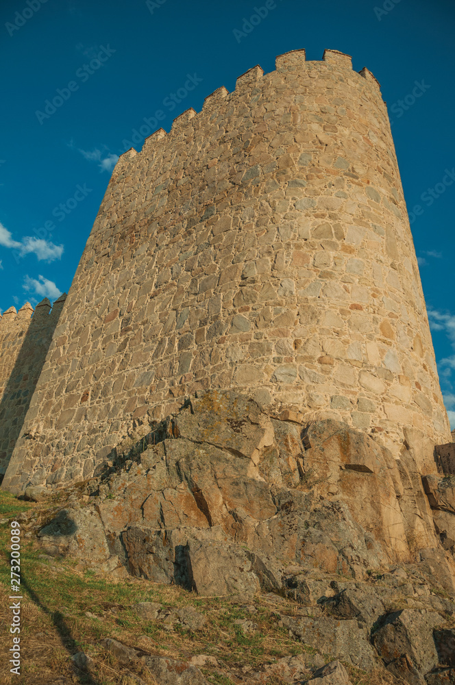 Stone tower in a large wall over rocky landscape in Avila