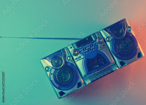 Retro wave, 80s. Audio cassette recorder with antenna and speakers in holographic light. Top view, minimalism photo