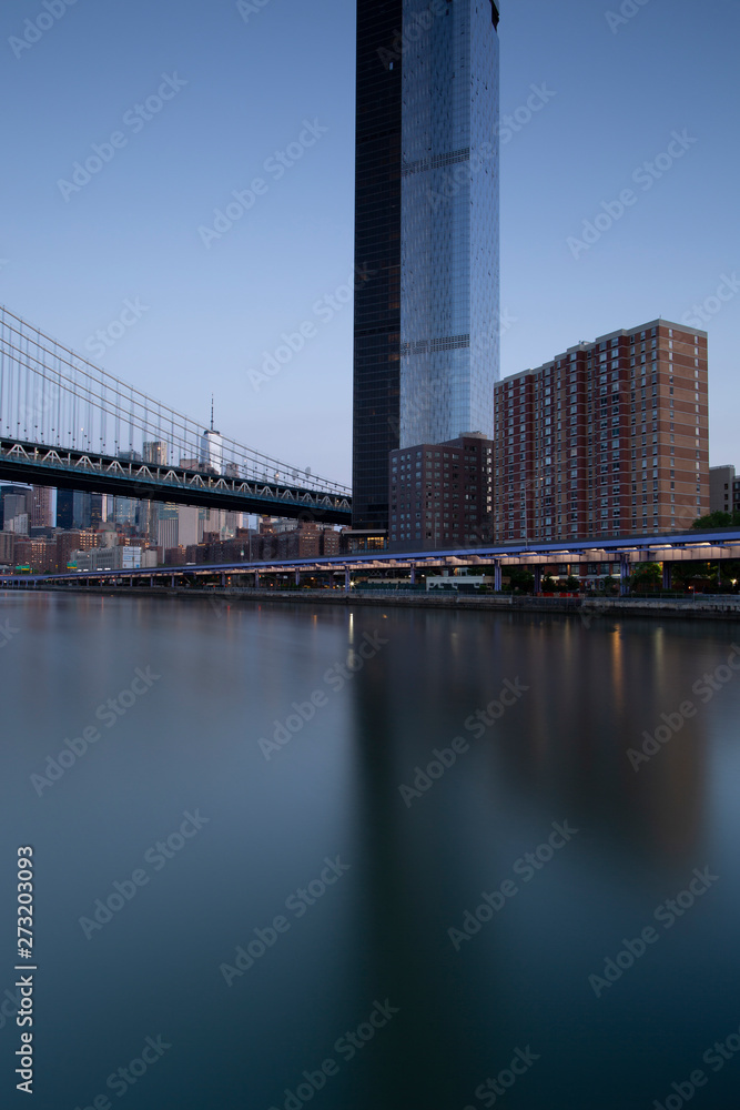 Fototapeta premium Financial District with One Manhattan Square building view from East River with long exposure during sunrise
