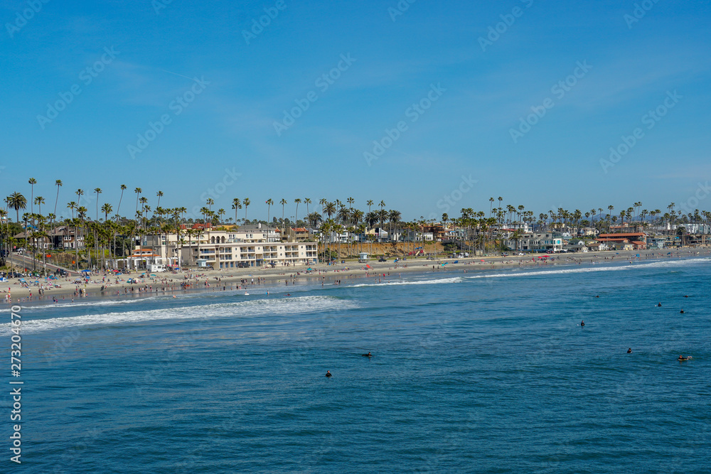 People on the beach enjoying beautiful spring day at Oceanside beach in San Diego, California. 